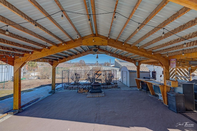 view of patio with an outdoor structure and a storage unit