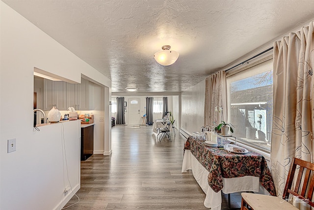 corridor featuring a textured ceiling and wood finished floors