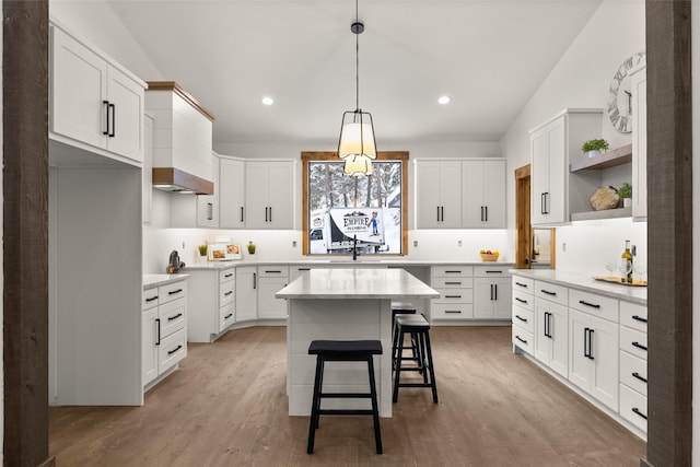 kitchen featuring white cabinetry, a center island, and a kitchen bar