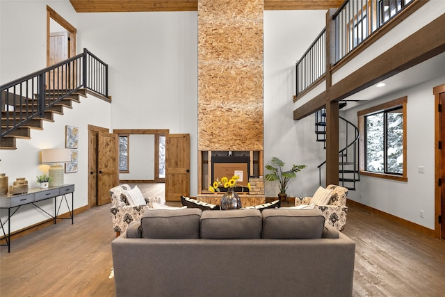 living room with a towering ceiling and light hardwood / wood-style flooring