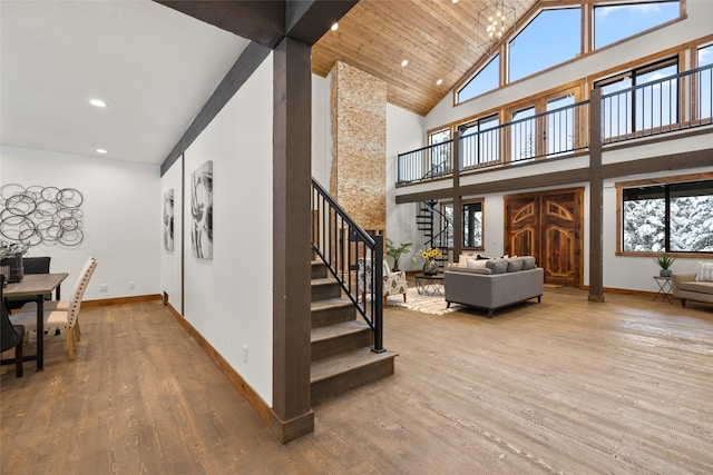 stairway featuring wood-type flooring, wooden ceiling, and high vaulted ceiling