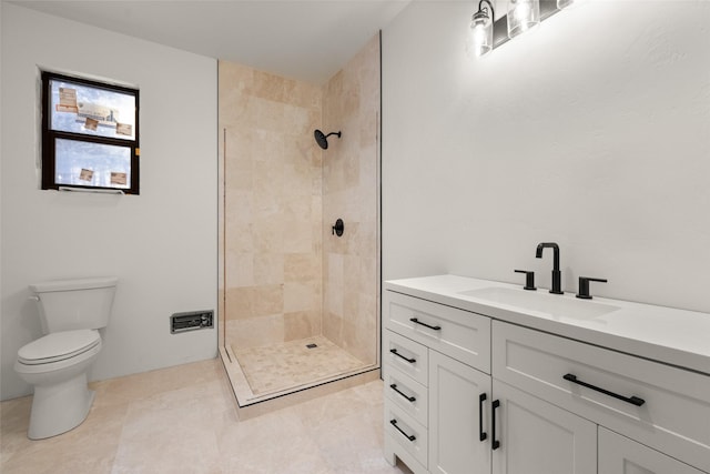 bathroom with vanity, tile patterned floors, toilet, and tiled shower