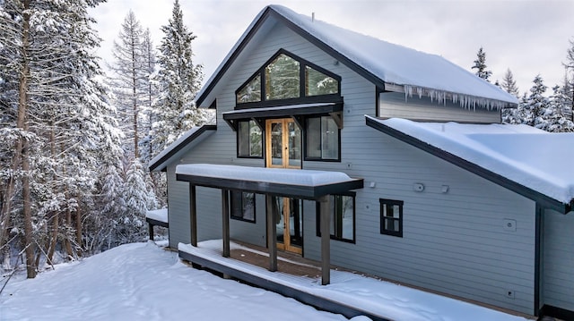 snow covered house featuring french doors