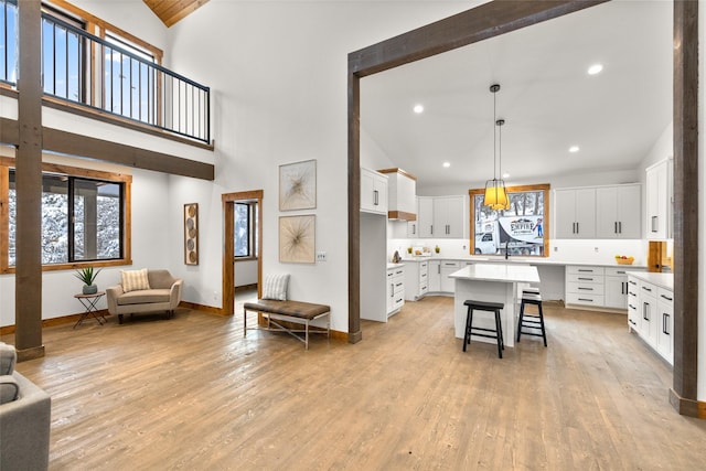 kitchen with white cabinetry, a center island, pendant lighting, and a kitchen bar