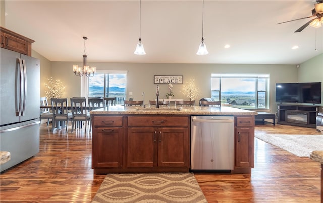 kitchen with pendant lighting, sink, a center island with sink, and appliances with stainless steel finishes