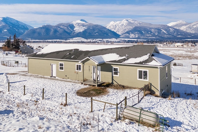 snow covered house featuring a mountain view