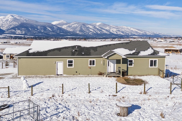 snow covered rear of property featuring a mountain view