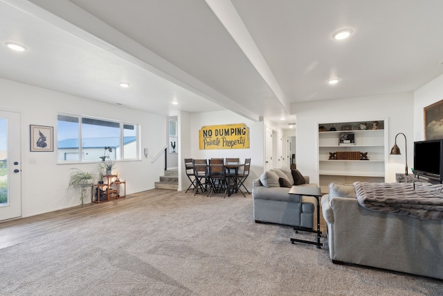 carpeted living room featuring beam ceiling and built in features