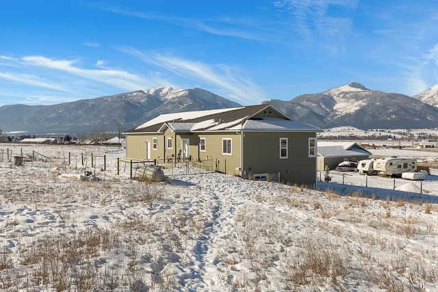 snow covered rear of property with a mountain view