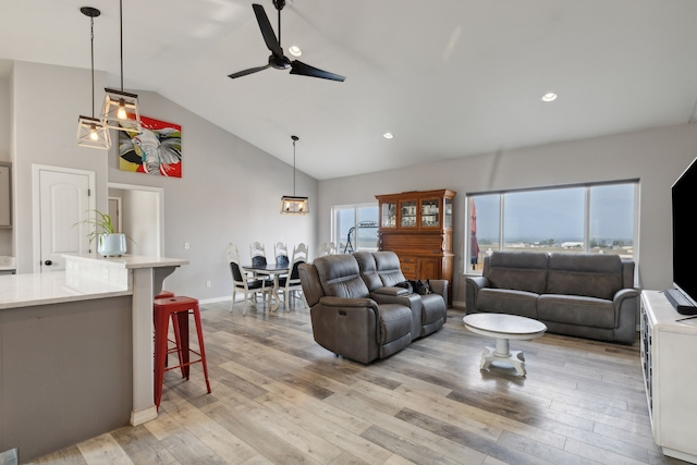 living room featuring ceiling fan, high vaulted ceiling, and light hardwood / wood-style floors