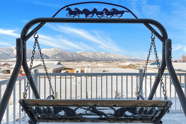 snow covered deck with a mountain view