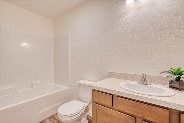 full bathroom featuring hardwood / wood-style flooring, vanity, tub / shower combination, and toilet