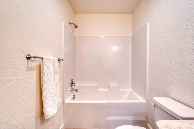 bathroom featuring tub / shower combination and toilet