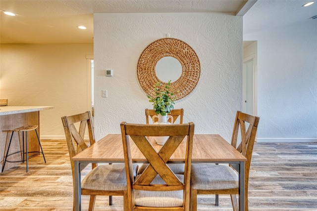 dining room with a textured ceiling and light hardwood / wood-style floors