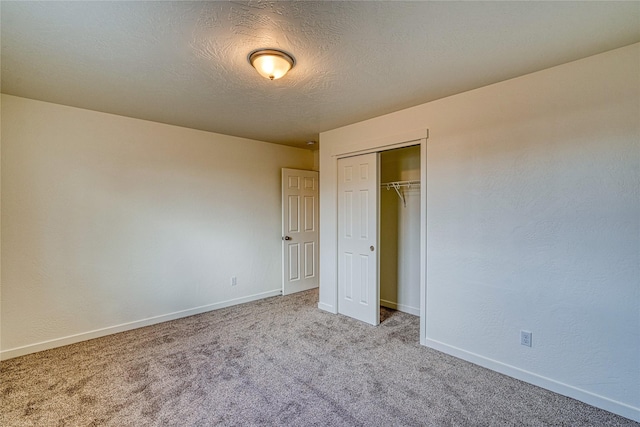 unfurnished bedroom with a closet, light carpet, and a textured ceiling