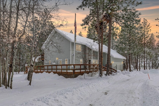 snow covered rear of property featuring a wooden deck