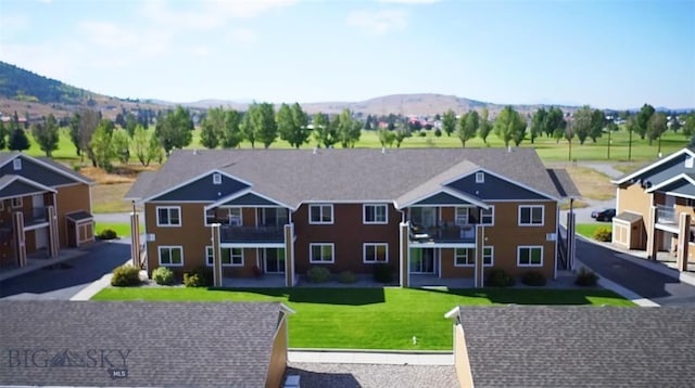 exterior space featuring a mountain view and a lawn