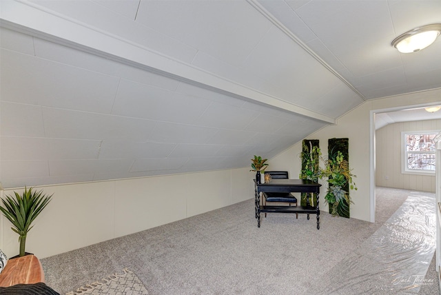 corridor featuring lofted ceiling and carpet floors