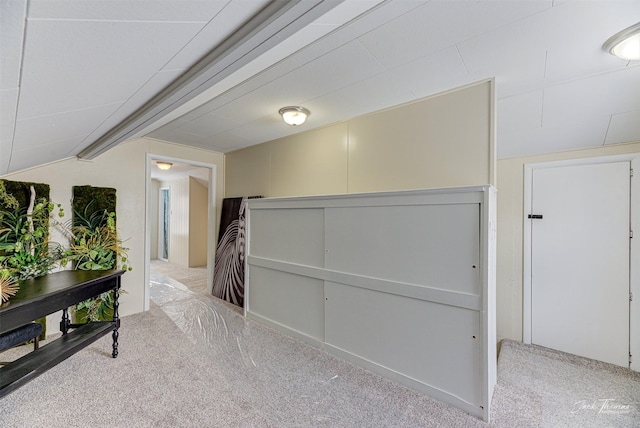 hall featuring vaulted ceiling and light carpet