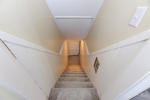 stairs featuring wooden walls