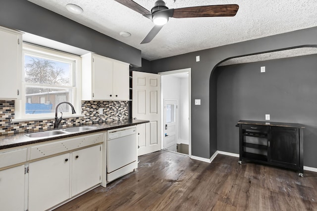 kitchen with sink, dishwasher, white cabinets, dark hardwood / wood-style flooring, and decorative backsplash