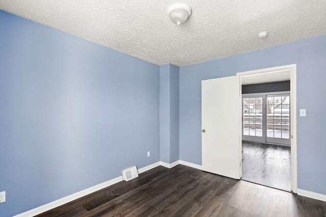 unfurnished room with dark hardwood / wood-style floors and a textured ceiling