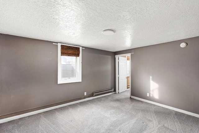 spare room featuring a baseboard heating unit, a textured ceiling, and carpet flooring