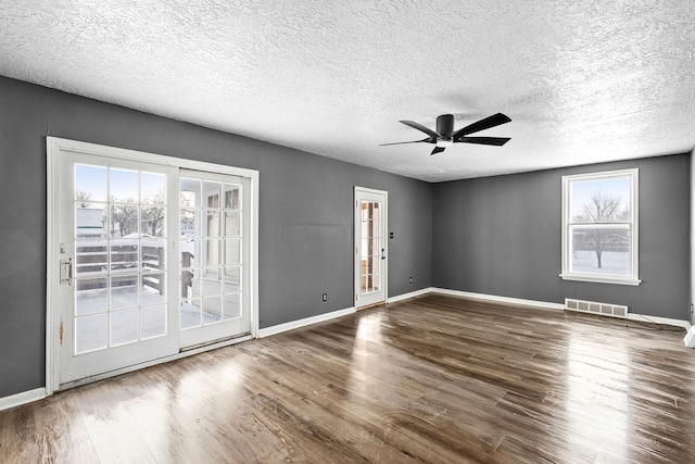 spare room featuring wood-type flooring, a textured ceiling, and ceiling fan