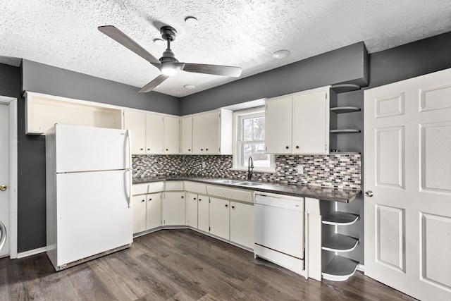 kitchen with tasteful backsplash, sink, dark wood-type flooring, and white appliances