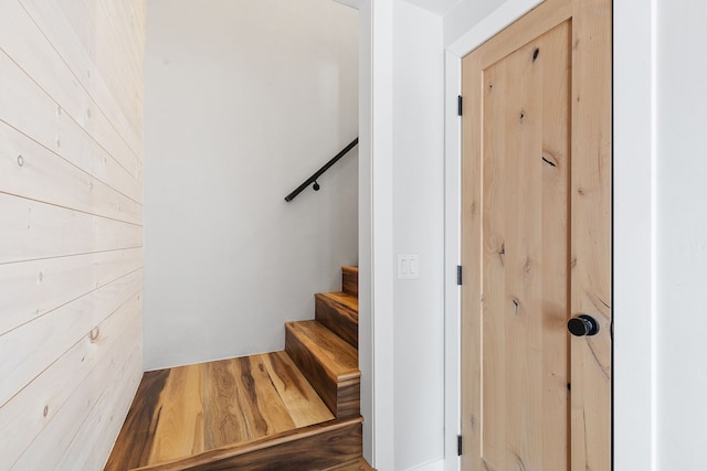 stairs featuring wood walls