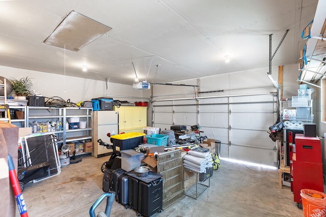 garage featuring a garage door opener and white fridge