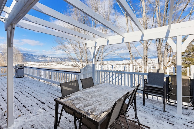 snow covered deck featuring area for grilling and a mountain view