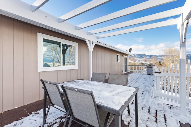 snow covered deck with a mountain view