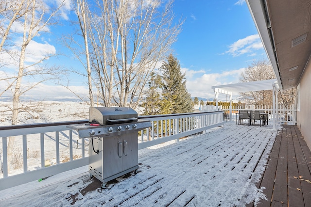 snow covered deck featuring grilling area and a pergola