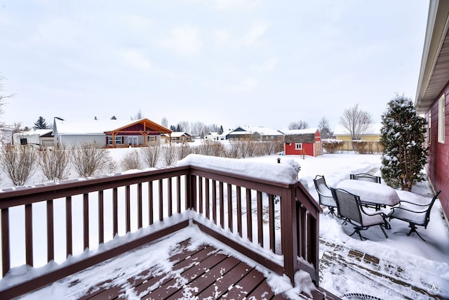 snow covered deck featuring a storage shed