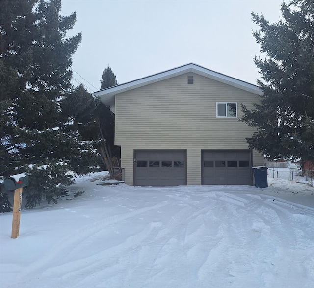 view of snowy exterior featuring a garage