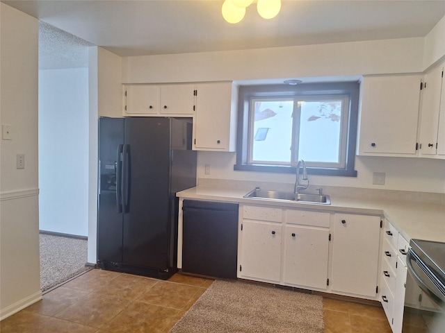 kitchen featuring light tile patterned floors, white cabinets, light countertops, black appliances, and a sink