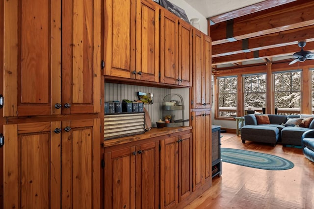 kitchen with beam ceiling, ceiling fan, and light wood-type flooring