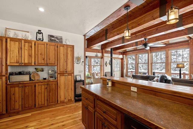 kitchen featuring hanging light fixtures, light wood-type flooring, beamed ceiling, ceiling fan, and backsplash