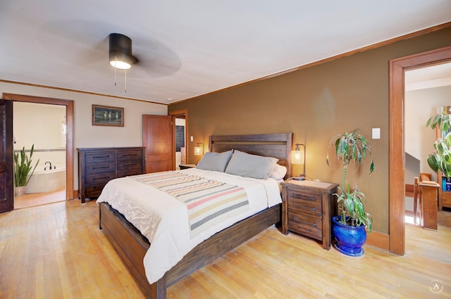 bedroom featuring ceiling fan, ornamental molding, connected bathroom, and light hardwood / wood-style floors