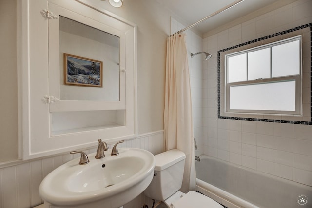 full bathroom featuring sink, shower / bath combination with curtain, and toilet