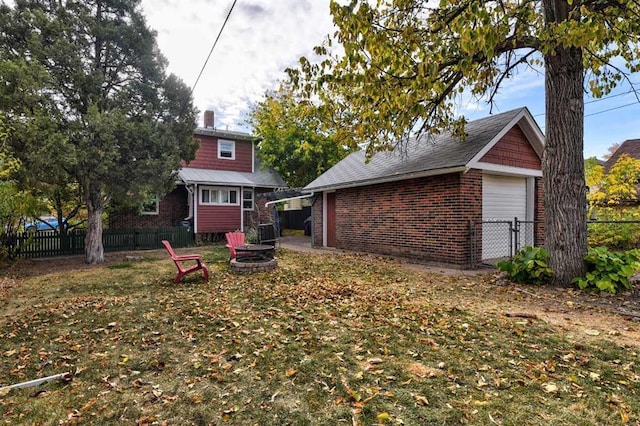 view of yard featuring a garage and a fire pit