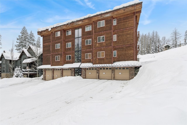 snow covered property featuring a garage