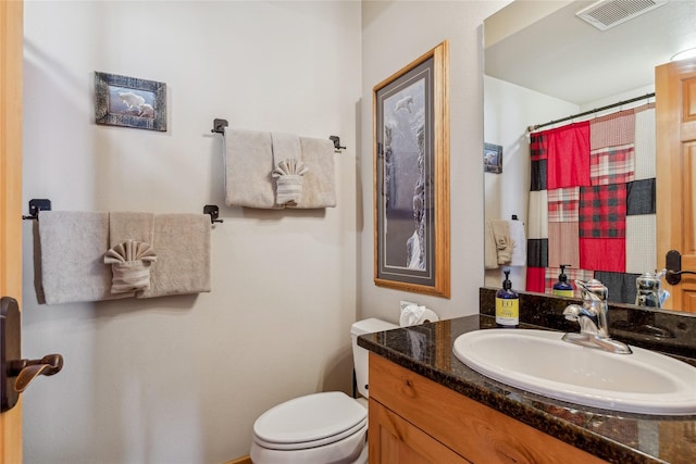 bathroom with walk in shower, vanity, and toilet