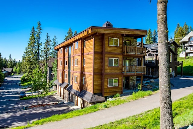 view of property exterior with a garage and a balcony