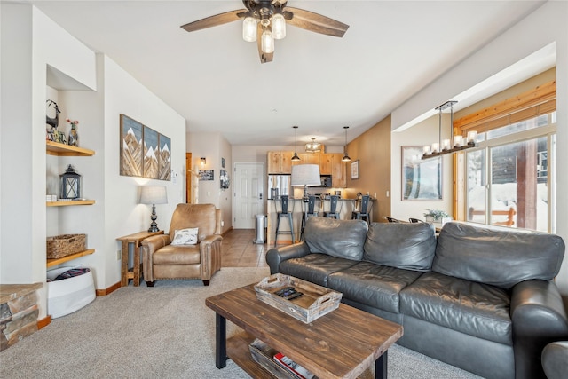 living room featuring ceiling fan with notable chandelier and light carpet