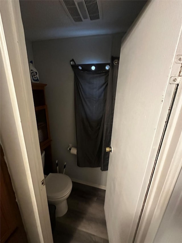 bathroom featuring hardwood / wood-style flooring and toilet