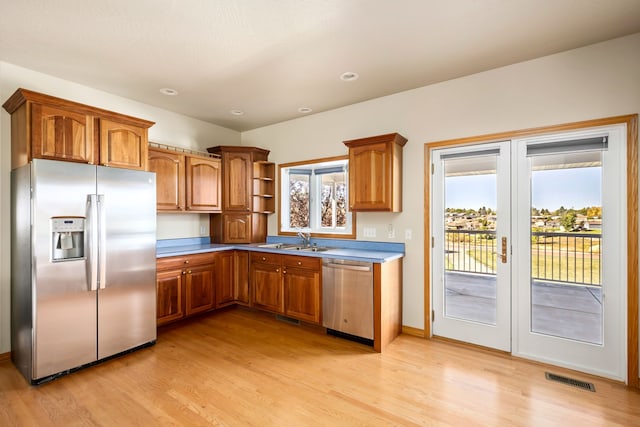 kitchen with visible vents, appliances with stainless steel finishes, brown cabinetry, and a sink