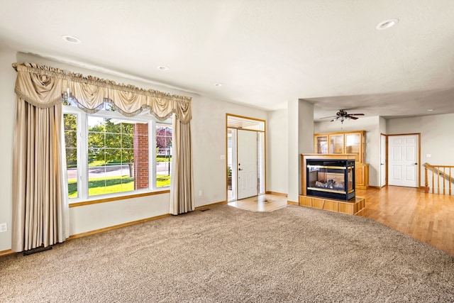 unfurnished living room with carpet, a fireplace, baseboards, and recessed lighting