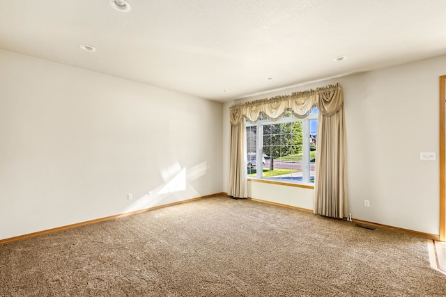 carpeted empty room featuring baseboards and recessed lighting